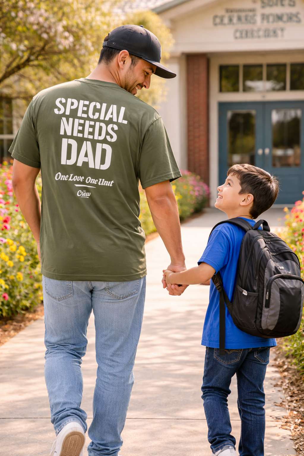 Man wearing a 'Special Needs Dad' shirt walking with a child holding hands outdoors.